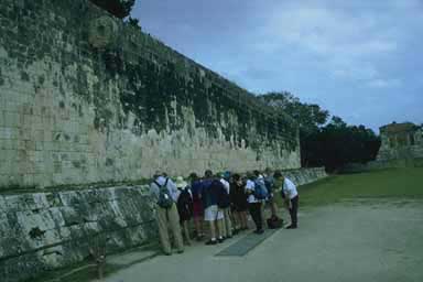 Group examining inscription on the side of the ballcourt